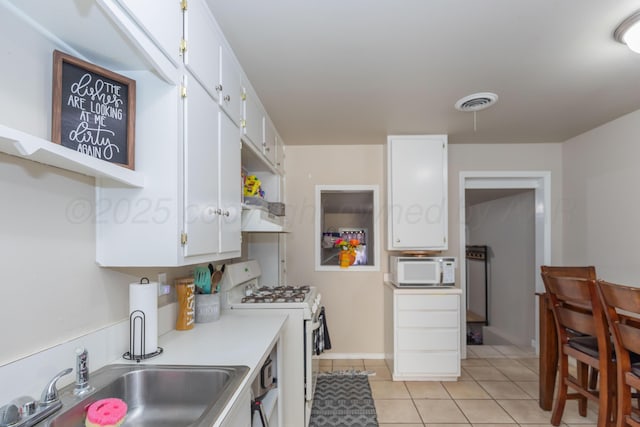 1910 S Seminole St, Amarillo, TX 79103 - kitchen with white appliances, white cabinetry, light tile patterned flooring, light countertops, and open shelves