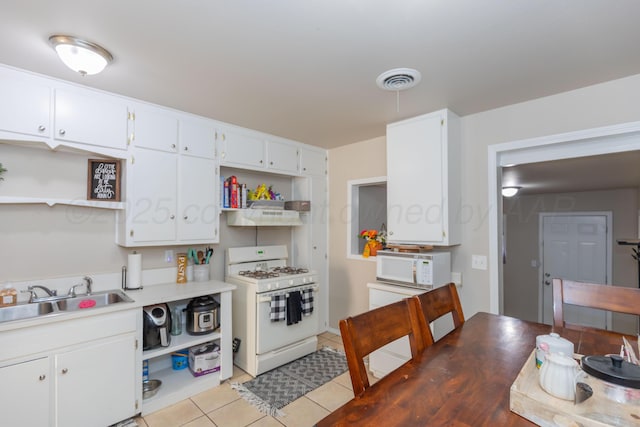 1910 S Seminole St, Amarillo, TX 79103 - kitchen with white appliances, open shelves, light tile patterned floors, and white cabinetry