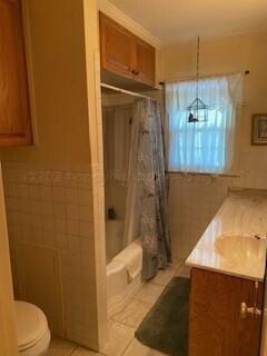 2237 Locust St, Amarillo, TX 79109 - bathroom featuring toilet, vanity, tile patterned floors, and shower / tub combo with curtain