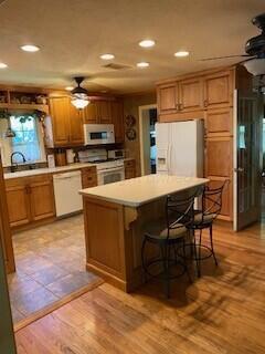 2237 Locust St, Amarillo, TX 79109 - kitchen with white appliances, a ceiling fan, recessed lighting, light countertops, and brown cabinetry