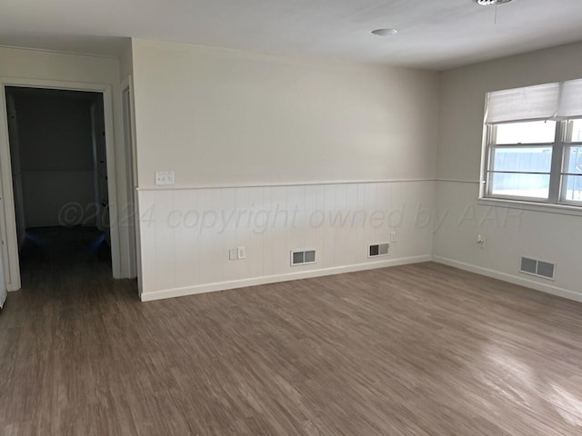 unfurnished room with dark wood-type flooring