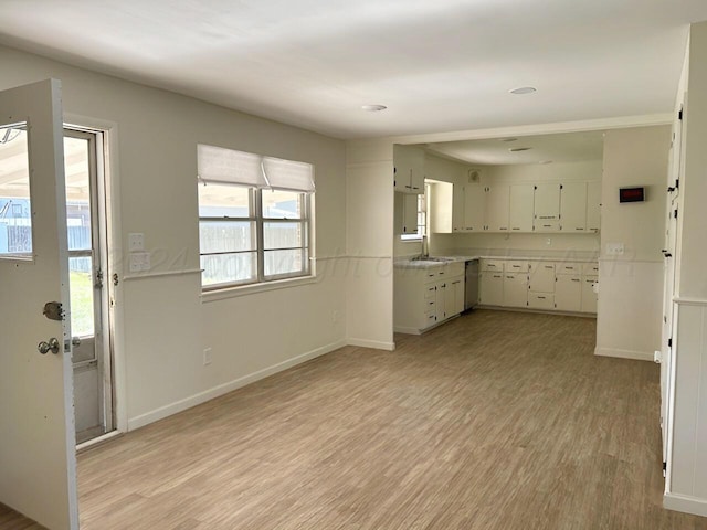 kitchen featuring white cabinets, light hardwood / wood-style flooring, stainless steel dishwasher, and sink