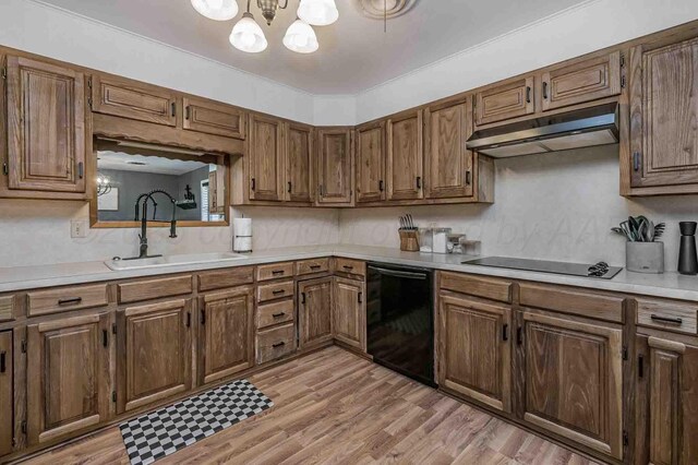 15 Fannin Dr, Tulia, TX 79088 - kitchen with a sink, under cabinet range hood, black appliances, and light countertops