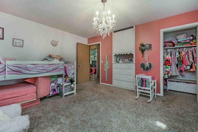 15 Fannin Dr, Tulia, TX 79088 - bedroom with carpet, a chandelier, a closet, a textured ceiling, and a spacious closet
