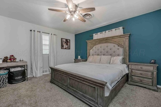 15 Fannin Dr, Tulia, TX 79088 - bedroom with light colored carpet, a ceiling fan, and baseboards