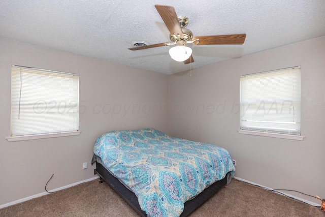 707 N Arkansas St, Shamrock, TX 79079 - carpeted bedroom with multiple windows, a textured ceiling, and a ceiling fan