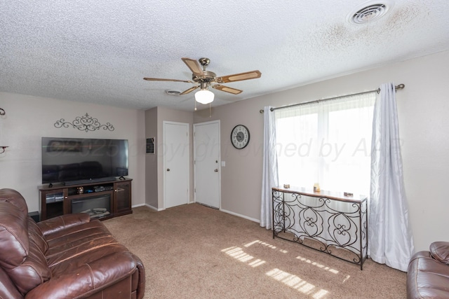 707 N Arkansas St, Shamrock, TX 79079 - living room featuring a ceiling fan, carpet flooring, and a textured ceiling