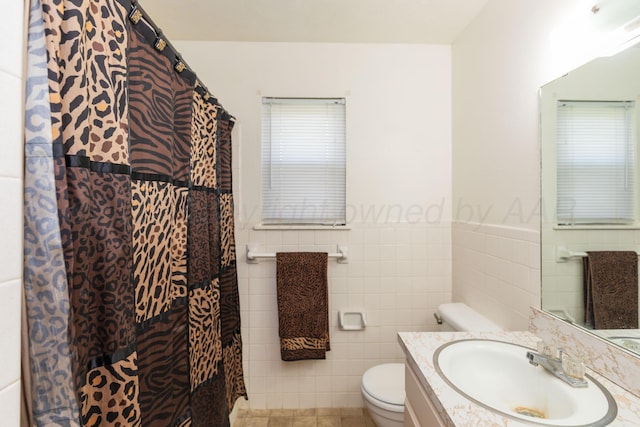 707 N Arkansas St, Shamrock, TX 79079 - full bathroom featuring tile walls, vanity, a wainscoted wall, and a shower with curtain