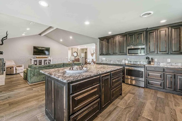 5800 Hester Rd, Amarillo, TX 79124 - kitchen featuring stainless steel appliances, light stone counters, wood finished floors, dark brown cabinetry, and open floor plan