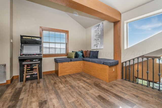 interior space featuring visible vents, baseboards, lofted ceiling, and wood finished floors