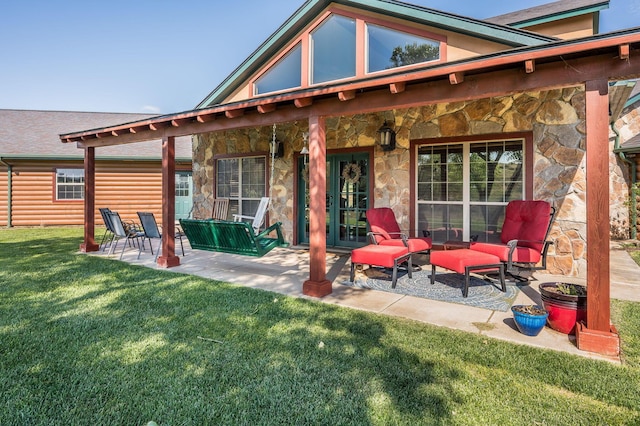 back of property featuring a lawn, a patio area, and stone siding