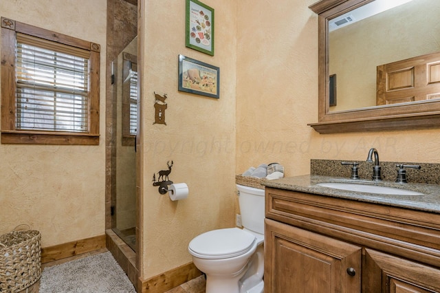 full bathroom with visible vents, vanity, baseboards, toilet, and tiled shower