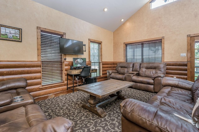 living area featuring high vaulted ceiling, a textured wall, rustic walls, and recessed lighting