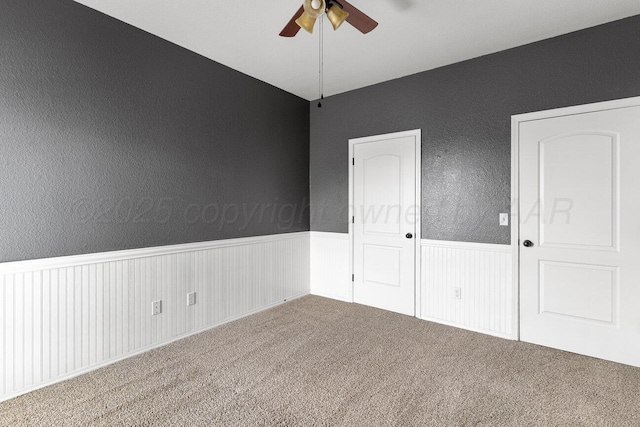 9909 Asher Ave, Amarillo, TX 79119 - empty room with ceiling fan, a wainscoted wall, carpet floors, and a textured wall