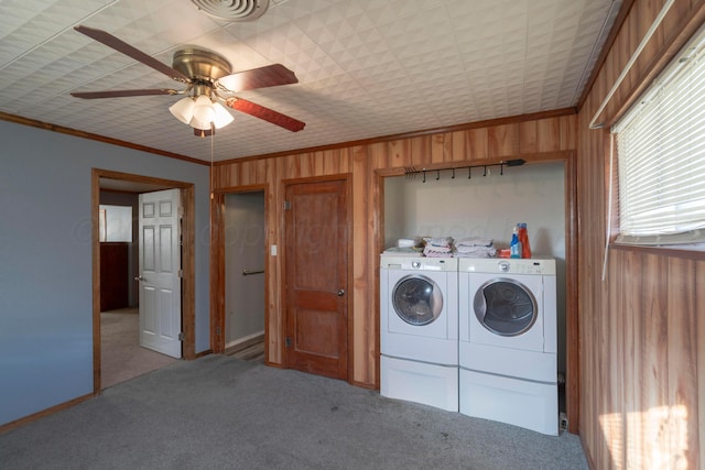 laundry area with ornamental molding, washer and clothes dryer, carpet, and wood walls