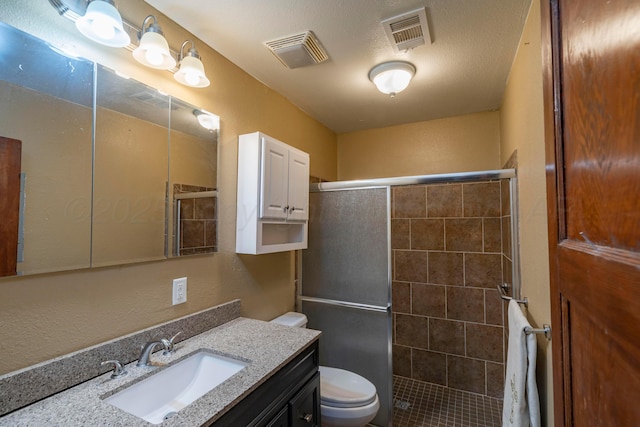 bathroom with vanity, an enclosed shower, a textured ceiling, and toilet