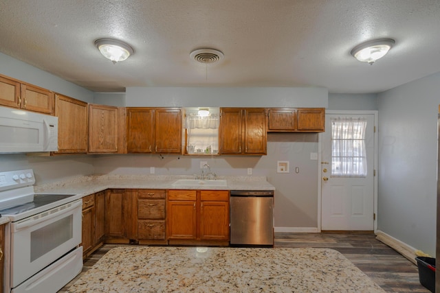 kitchen with white appliances, dark hardwood / wood-style flooring, sink, and a textured ceiling