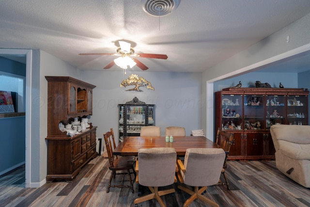 dining room with dark hardwood / wood-style flooring, ceiling fan, and a textured ceiling