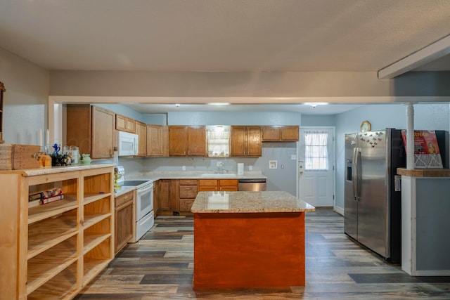 kitchen featuring stainless steel appliances, a center island, sink, and dark wood-type flooring