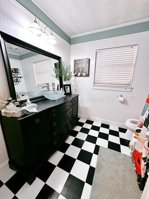 bathroom featuring crown molding, toilet, vanity, baseboards, and tile patterned floors