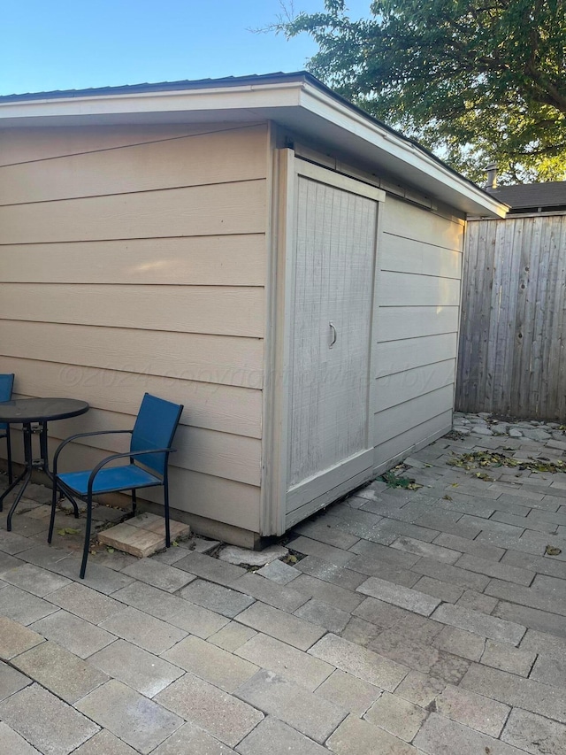 view of outbuilding featuring fence