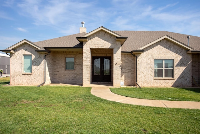 view of front of house featuring a front yard and french doors