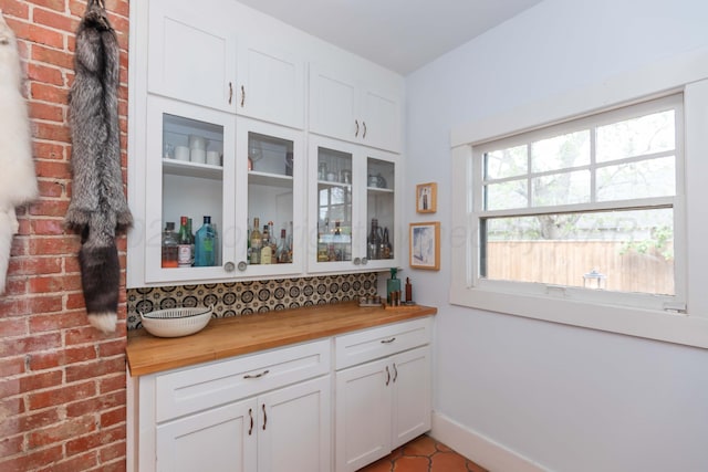 indoor dry bar featuring baseboards and tile patterned flooring