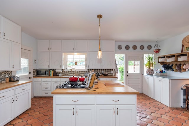 kitchen featuring wooden counters, stainless steel appliances, backsplash, and healthy amount of natural light