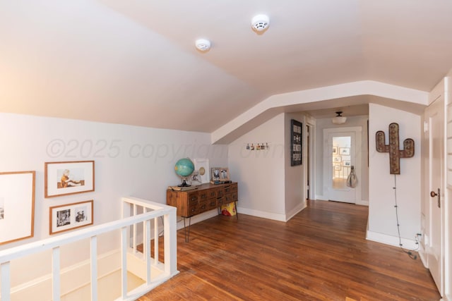 additional living space with wood finished floors, lofted ceiling, and baseboards