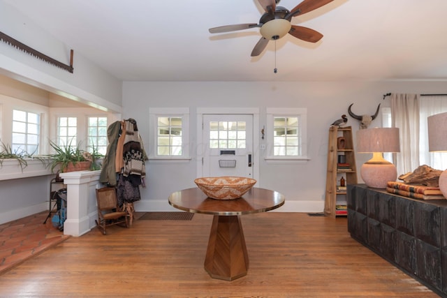 dining area featuring baseboards, a ceiling fan, and wood finished floors