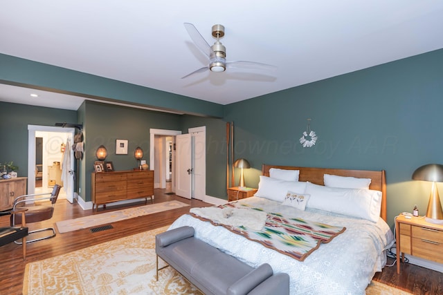 bedroom with wood finished floors, baseboards, and a ceiling fan