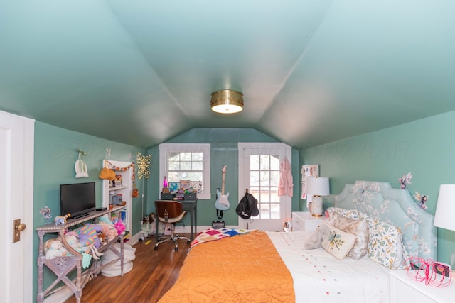 bedroom with wood finished floors and vaulted ceiling