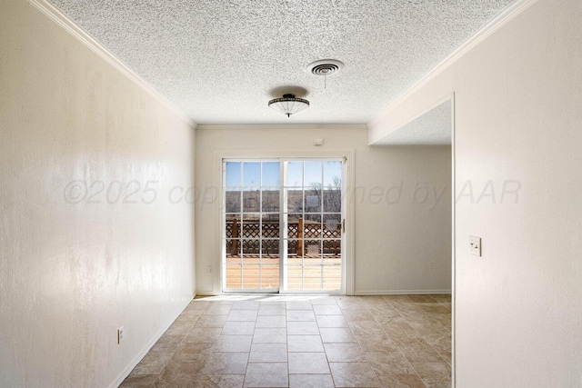 spare room featuring baseboards, ornamental molding, a textured ceiling, and visible vents