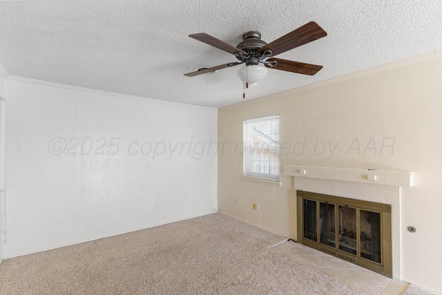 unfurnished living room featuring carpet flooring, a textured ceiling, a glass covered fireplace, ceiling fan, and crown molding