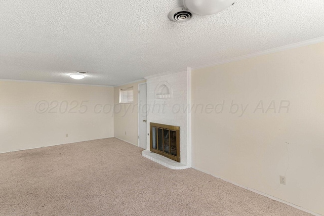 unfurnished living room featuring a brick fireplace, carpet floors, visible vents, and a textured ceiling