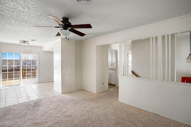 carpeted empty room featuring ceiling fan, ornamental molding, a textured ceiling, and visible vents