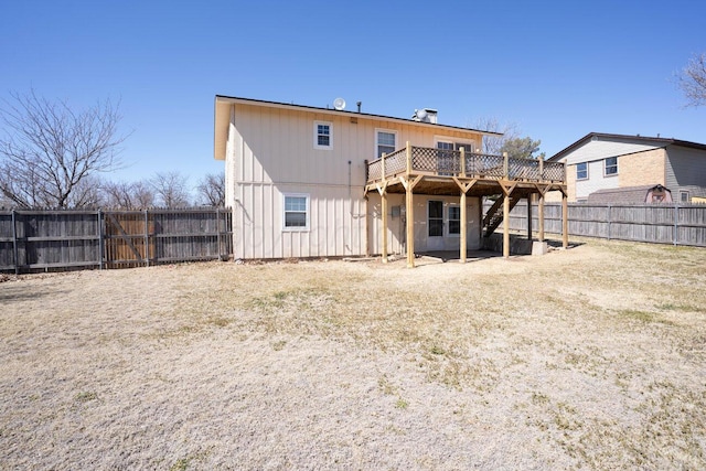 back of house featuring a wooden deck, a fenced backyard, and stairs