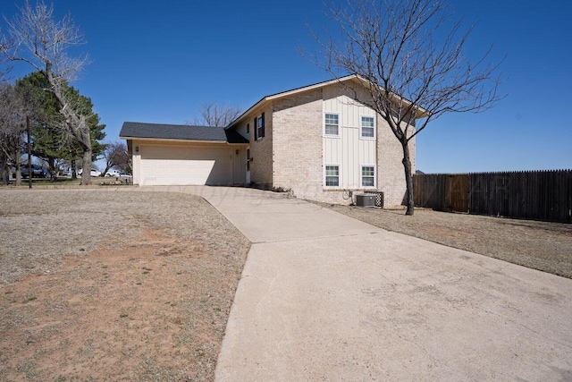 view of property exterior with cooling unit, driveway, fence, brick siding, and an attached garage