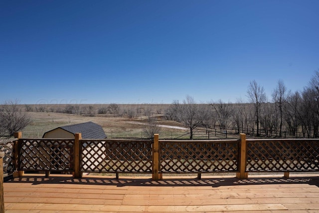 wooden deck featuring an outdoor structure and a storage unit