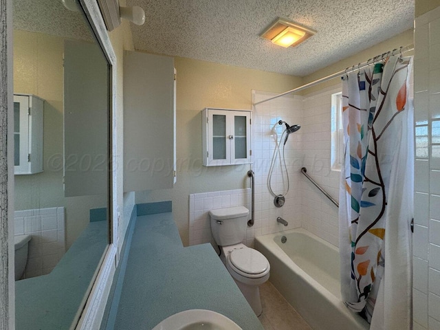 bathroom with tile patterned flooring, shower / tub combo with curtain, a textured ceiling, and toilet