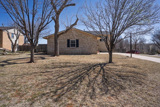 view of property exterior with fence and brick siding