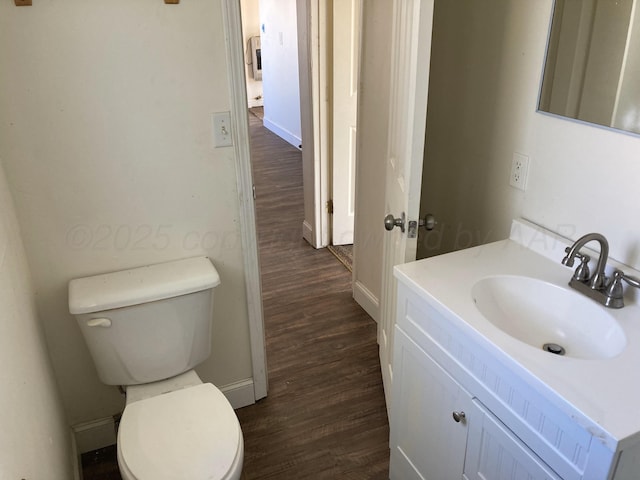 409 N Alabama St, Amarillo, TX 79106 - half bathroom featuring wood finished floors, toilet, vanity, and baseboards