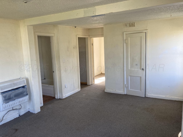 409 N Alabama St, Amarillo, TX 79106 - carpeted spare room with heating unit, a textured ceiling, and baseboards