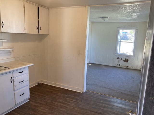 409 N Alabama St, Amarillo, TX 79106 - kitchen featuring white cabinetry, light countertops, dark wood-style flooring, baseboards, and a textured ceiling