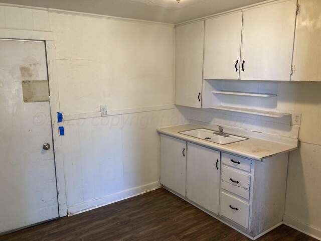 409 N Alabama St, Amarillo, TX 79106 - kitchen with a sink, dark wood-type flooring, light countertops, white cabinets, and baseboards