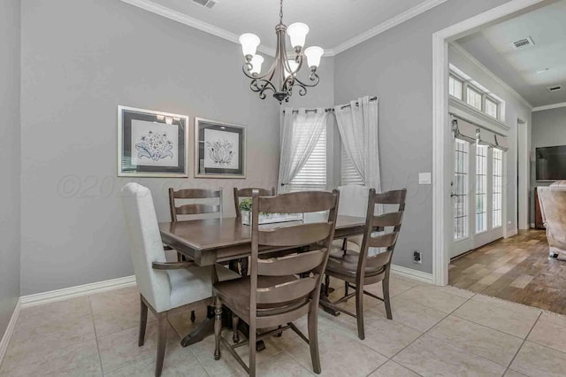dining space with ornamental molding, a chandelier, baseboards, and light tile patterned floors