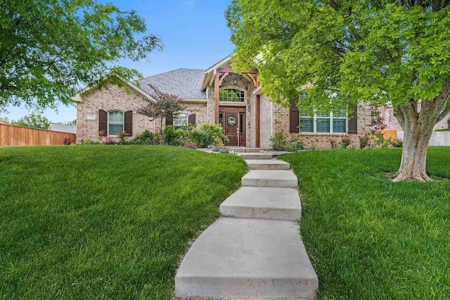 view of property hidden behind natural elements featuring brick siding