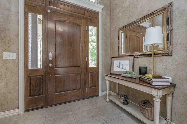 entryway featuring light tile patterned floors and baseboards