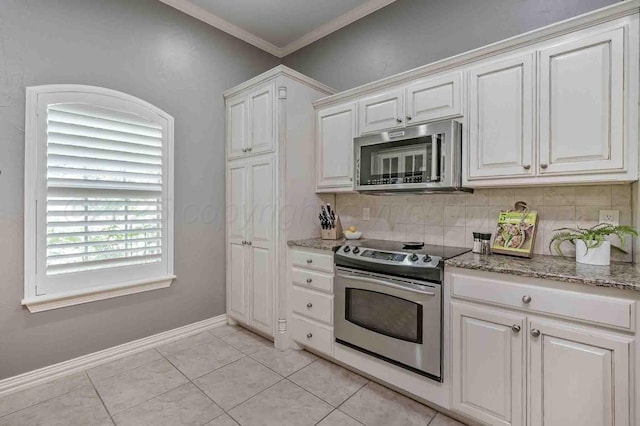 kitchen with appliances with stainless steel finishes, light stone countertops, white cabinets, tasteful backsplash, and baseboards