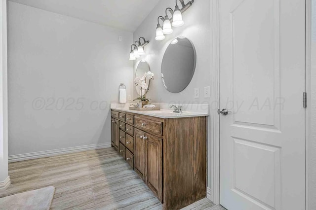 full bathroom with double vanity and baseboards